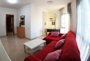 大塔拉哈尔Apartamento vistas al mar, wifi de 600 Mb的客厅配有红色的沙发和桌子