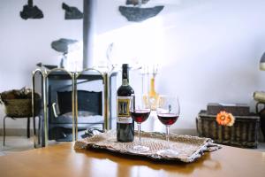 莫朗Os 5 Sentidos的桌子上放有一瓶葡萄酒和两杯酒