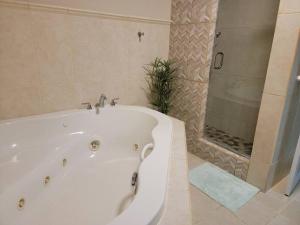卡沃罗霍Private Beachfront House的带淋浴的浴室配有白色浴缸。