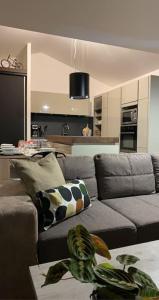 AussonneMEET - AIRBUS - TRAMWAY的一间带灰色沙发的客厅和一间厨房