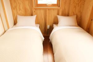 美瑛町福托格美瑛旅馆的小型客房设有两张单人床和窗户。