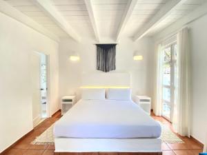 库埃纳瓦卡Hotel Cala Blanca Cuernavaca的白色卧室配有一张带白色床单的大床
