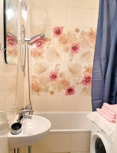 奥尔什丁Apartament pod Pawiem的浴室设有水槽和墙上的鲜花淋浴。
