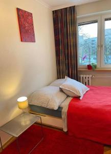 奥尔什丁Apartament pod Pawiem的一间卧室设有红色的床和窗户。