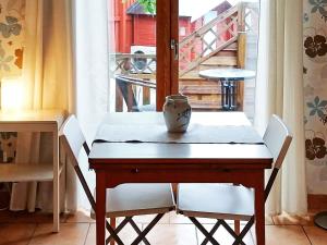 HällsvikHoliday home in Torslanda 2的一张桌子,上面有白色的椅子和花瓶