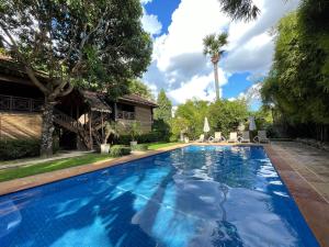 暹粒吴哥棕榈园酒店的一座树木繁茂的房屋后院的游泳池