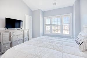 默特尔比奇Carnation 302的白色卧室配有床和平面电视