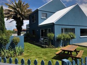 Temuka凤凰汽车旅馆的庭院里带野餐桌的蓝色房子