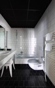布鲁塞尔祖姆酒店的白色的浴室设有浴缸和水槽。