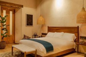 圣克里斯托瓦尔-德拉斯卡萨斯Taller de Juan - Casa Hotel的一间卧室配有一张大床和吊灯