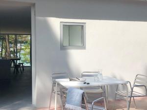 里贝拉Apartamentos Camping Coroso的白色的桌子、椅子和墙上的镜子