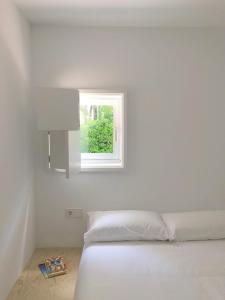 里贝拉Apartamentos Camping Coroso的白色的卧室设有床和窗户