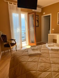 利莫内-苏尔加达Villa Castello only room的一间卧室设有一张大床、一把椅子和窗户。