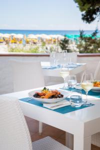 卡拉·利贝罗托Tirreno Resort的一张桌子,上面放着一盘食物和酒杯