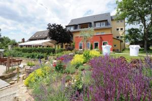 巴特司塔福斯坦班泽尔瓦尔德贝格酒店的一座花园,在房子前面种有紫色的花朵