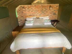 法尔瓦特Limpopo Bushveld Retreat的砖墙房间的一个床位