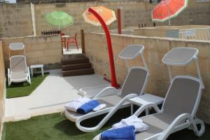 QormiPalazzino Nina Boutique Hotel的地面上一组椅子和遮阳伞