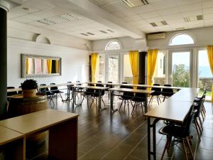 伊佐拉Hotel Stara šola - Oleander Resort的用餐室设有桌椅和窗户。