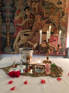 圣利斯Château Ratou的一张桌子,上面有带蜡烛和红玫瑰的桌布