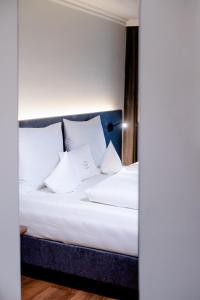瓦兹沃尔赛沃特酒店的一间卧室配有带白色床单和枕头的床。