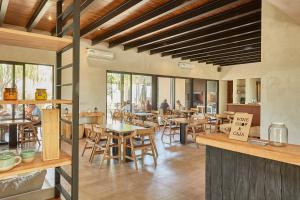 Los SaucesCasa de Huéspedes Bodega Gimenez Riili的餐厅设有木桌、椅子和窗户。