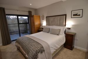 惠茨特布尔The Burrow at Tankerton的卧室设有一张白色大床和一扇窗户。