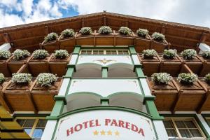 卡纳泽伊Hotel Pareda的一座酒店石榴建筑,上面有盆栽植物
