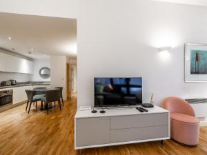 伦敦Pass the Keys - Modern Studio Apartment in the heart of Shoreditch的客厅配有电视和桌椅
