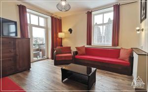 拉布卡Przystanek Rabka - Apartamenty w centrum的客厅配有红色沙发和电视