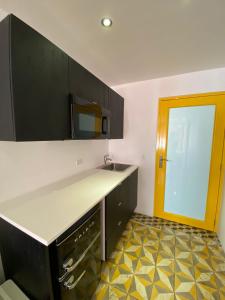 圣胡安Hotel Nest的厨房配有黑色橱柜和黄色门
