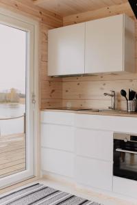 JorvasVilla Varis的厨房配有白色橱柜和窗户。