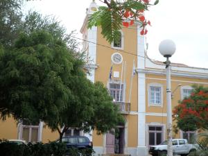 普拉亚Casa Privada do Plateau的黄色的建筑,旁边是钟