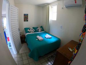嘎林海斯港Porto Paraiso Hostel的一间小卧室,配有带两个枕头的绿色床