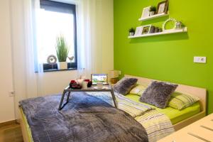 巴诺夫茨Apartmaji BANONIA " Poletni vetrc "的绿色卧室,配有一张桌子和一张床铺