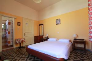 罗德镇阿纳斯塔西娅酒店的卧室设有一张白色大床和黄色墙壁