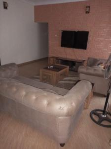 Idimu2 bedroom service apartment with full services的带沙发和电视的客厅