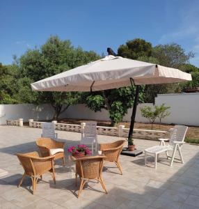 普尔萨诺Villa Cohiba - 700m dal mare的庭院里配有桌椅和遮阳伞