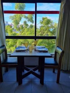 若昂佩索阿Quarto 215 do Manos Royal Hotel - propriedade privada的配有大窗户的客房内的桌椅