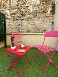 珀套特科姆博特Bulle d'Amour的两张粉红色的椅子和一张带鲜花的桌子