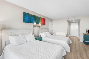 德斯坦Sandestin Resorts, Bayside, 3rd Floor, Bay Front Studio的配有白色床单的酒店客房内的两张床