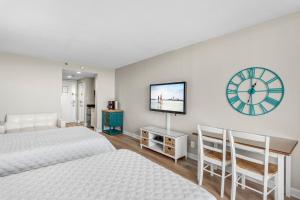 德斯坦Sandestin Resorts, Bayside, 3rd Floor, Bay Front Studio的一间卧室设有两张床,墙上挂着一个时钟。