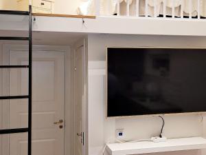 Torshälla4 person holiday home in TORSH LLA的一间卧室设有一张高架床和一台平面电视。