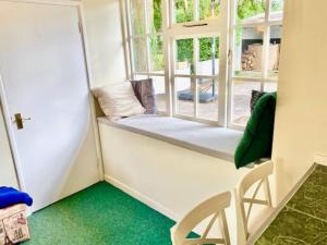 科克Cosy 2 bed cottage next to Fota Wildlife Park的客房设有带长椅和椅子的窗户。