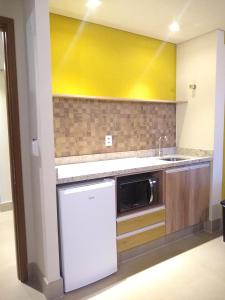 奥林匹亚Grein Solar das Águas Park Resort的厨房配有水槽和微波炉