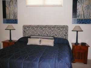 双水域木兰巷公寓酒店的一间卧室配有一张带两盏灯的蓝色床。