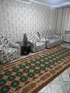 休钦斯克Квартира в районе жд вокзала的客厅配有两张沙发和地毯。
