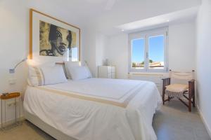 科洛尼亚圣霍尔迪CANAMI... Luxury apartment with best sea views.的卧室配有一张白色大床,墙上挂有绘画作品