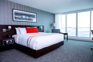 温尼伯湖畔温尼伯机场大酒店的酒店客房设有一张大床和窗户。