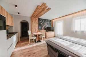 坎皮泰洛迪法萨Cesa Edelweiss Living & Spa的一间卧室配有一张床和一张桌子及椅子