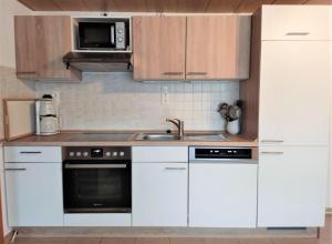 KleingießhübelFerienwohnung-Nickl的厨房配有白色橱柜、水槽和微波炉